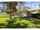 Landscaped backyard with screened porch and green space at 1687 Starling Drive, Tarpon Springs, FL 34689