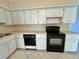 Kitchen with white cabinets and black appliances at 2284 Philippine Dr # 9, Clearwater, FL 33763