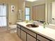 Bathroom with brown vanity, toilet, and shower; access to patio at 2460 W Marion Ave, Punta Gorda, FL 33950