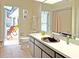 Bathroom with brown vanity, toilet, shower, and view of patio with seating at 2460 W Marion Ave, Punta Gorda, FL 33950