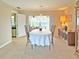 Dining room with a large table, chairs, and access to a screened-in patio and kitchen at 2460 W Marion Ave, Punta Gorda, FL 33950