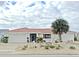 Front view of a white, single-story home with a red tile roof and attached garage at 2460 W Marion Ave, Punta Gorda, FL 33950
