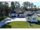 White two-story house with gray roof, stone driveway, and large backyard at 4675 Hickory Oak Dr, Brooksville, FL 34601