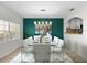 Bright dining room with a glass table, white chairs, and a teal accent wall at 5222 S Russell St # 25, Tampa, FL 33611