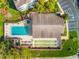 Aerial shot showcasing a pool, shuffleboard, and clubhouse surrounded by lush greenery and parking area at 8019 Feather Ct # C, Hudson, FL 34667