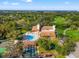 An aerial view featuring the pool, tennis courts, shuffleboard, and golf course at 8019 Feather Ct # C, Hudson, FL 34667