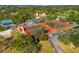 Aerial showing the well-maintained tennis courts, mature trees, and a charming blue building at 8019 Feather Ct # C, Hudson, FL 34667