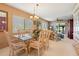 Bright dining room featuring a glass-top table, chandelier, and large windows bringing in natural light at 8019 Feather Ct # C, Hudson, FL 34667