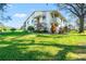 A two-story condo building featuring balconies, lush landscaping, and a vibrant green lawn in a sunny setting at 8019 Feather Ct # C, Hudson, FL 34667