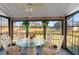 Screened porch with glass-top table and chairs, overlooking yard at 8019 Feather Ct # C, Hudson, FL 34667