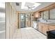 Bright kitchen featuring tile floors, wood cabinets, stainless steel appliances, and outdoor access at 8019 Feather Ct # C, Hudson, FL 34667