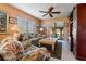 Inviting living room with floral-patterned furniture, ceiling fan, and sliding glass doors to the lanai at 8019 Feather Ct # C, Hudson, FL 34667