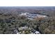 Aerial view of houses nestled in a wooded area with a pond at 11806 White Ash Dr, New Port Richey, FL 34654