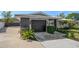 View of a well-kept home with a dark garage door and a freshly sealed concrete driveway at 13632 Imperial Groves S Dr, Largo, FL 33774