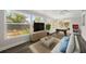 Bright living room with large windows, modern furnishings, a pool table, and view of the pool at 13632 Imperial Groves S Dr, Largo, FL 33774