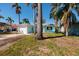 Charming light teal home with a one-car garage and lush landscaping at 17726 Long Point Dr, Redington Shores, FL 33708