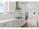 Kitchen with white cabinets, herringbone backsplash, stainless steel appliances, and hardwood floors at 2021 Amelia Bay Pl, Valrico, FL 33596