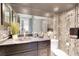 Elegant bathroom with dark vanity and bamboo wallpaper at 4575 Cove Cir # 202, St Petersburg, FL 33708