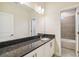 Bathroom with granite countertop, double sink, and white cabinets at 5825 1/2 S 5Th St, Tampa, FL 33611