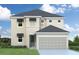 Two-story house with beige siding, gray roof, and two-car garage at 5825 1/2 S 5Th St, Tampa, FL 33611