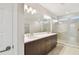 Modern bathroom featuring double vanity sinks, large mirrors, and a tiled walk-in shower at 5825 S 5Th St, Tampa, FL 33611