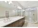 This bathroom offers a double vanity, large mirror, and tiled walk-in shower at 5825 S 5Th St, Tampa, FL 33611