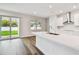 Open concept kitchen island featuring a stainless steel sink and access to the backyard through sliding doors at 5825 S 5Th St, Tampa, FL 33611