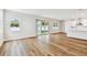 Bright open-concept living room with wood floors and sliding glass doors to the backyard at 5825 S 5Th St, Tampa, FL 33611