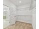 Spacious walk-in closet featuring metal shelving and plush carpeting, adjacent to a modern bathroom with a glass-enclosed shower at 5825 S 5Th St, Tampa, FL 33611