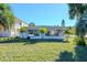Ranch style home with a large grassy front yard and tropical landscaping at 603 Virginia Ave, Tarpon Springs, FL 34689