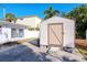 White storage shed with a light brown door at 603 Virginia Ave, Tarpon Springs, FL 34689