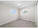 Simple bedroom with carpeted floor, neutral walls and two windows at 35209 Ada Ave, Zephyrhills, FL 33541