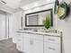 Bright bathroom with white cabinets, marble countertop, and decorative mirror at 11211 60Th Ave, Seminole, FL 33772