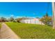 Beautiful front yard with green grass, pretty plants, and a white fence in the background at 11211 60Th Ave, Seminole, FL 33772