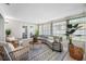 Cozy sunroom featuring a sectional sofa, rattan chairs, and many windows at 11211 60Th Ave, Seminole, FL 33772