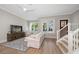 Living room with hardwood floors, white couch, and a large TV at 12 Country Club Ln, Belleair, FL 33756