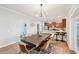 Modern dining room adjacent to the kitchen, featuring a long wooden table and leather chairs at 1730 Bonita Bluff Ct, Ruskin, FL 33570