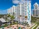 Exterior view of white condominium building with balconies and palm trees, enhanced by the blue sky at 2401 Bayshore Blvd # 410 & 510, Tampa, FL 33629