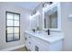 Updated bathroom with white vanity, quartz countertops, and large mirror at 4608 Glenside Cir, Tampa, FL 33624