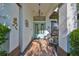 Inviting front porch with a light blue double door, wicker chairs, and decorative accents at 6646 Park Strand Dr, Apollo Beach, FL 33572