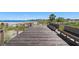 Wooden boardwalk leads to a sandy beach with seating areas at 795 Collany Rd # 304, St Petersburg, FL 33715