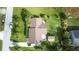 A bird's-eye view of a well-maintained home with a brown roof, green lawn, and some palm trees at 109 San Rafael Ave, North Port, FL 34287