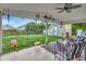 Covered back porch with seating and a view of the expansive lawn and a storage shed at 109 San Rafael Ave, North Port, FL 34287