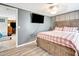 Cozy bedroom with a rustic wooden bed frame, a mounted flat-screen TV, and modern gray walls at 109 San Rafael Ave, North Port, FL 34287
