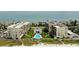 Aerial view of beachfront condos with lush green landscaping and a sparkling blue swimming pool at 1430 Gulf Blvd # 204, Clearwater Beach, FL 33767