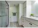 Bathroom with white cabinets, a shower, and laminate wood flooring at 1430 Gulf Blvd # 204, Clearwater Beach, FL 33767