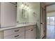 Charming bathroom featuring drawers, white cabinets, framed mirror, and adjacent room with sliding glass doors at 1430 Gulf Blvd # 204, Clearwater Beach, FL 33767
