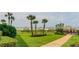 Expansive greenspace leading to the beach, complete with palm trees and shaded seating areas for residents at 1430 Gulf Blvd # 204, Clearwater Beach, FL 33767