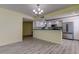 Open-concept kitchen flows into the living area, featuring stainless steel appliances and laminate floors at 1430 Gulf Blvd # 204, Clearwater Beach, FL 33767