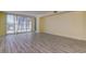 Spacious living room with a sliding glass doors, laminate flooring, and sunny yellow walls at 1430 Gulf Blvd # 204, Clearwater Beach, FL 33767